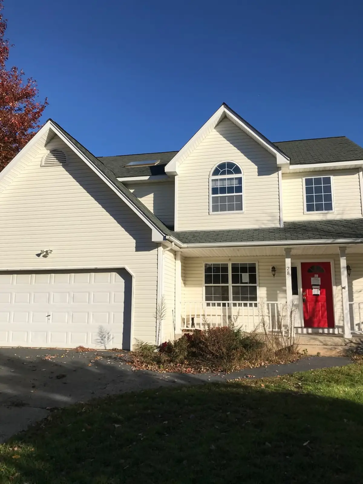 Two-story colonial with a red front door and a front porch, Commack, NY