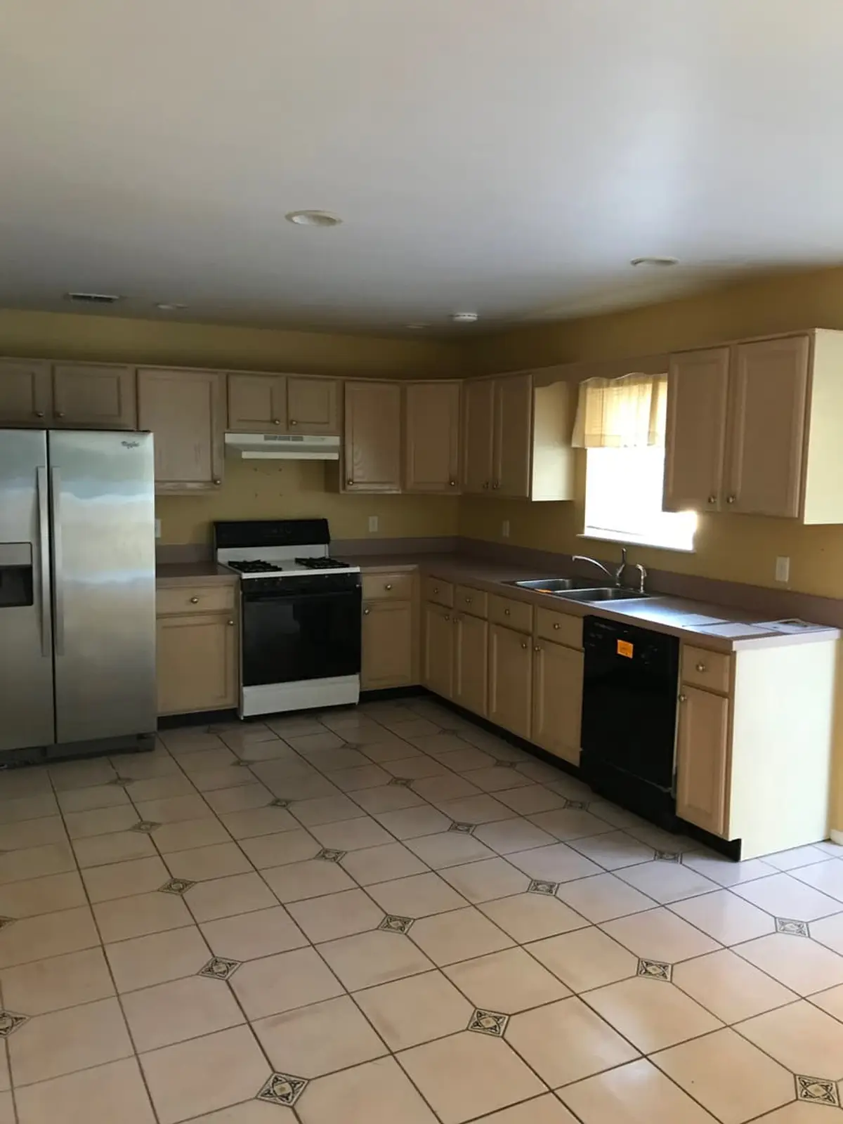 Selling a house after a life change in Commack: vacant kitchen with light wood cabinets and a tiled floor